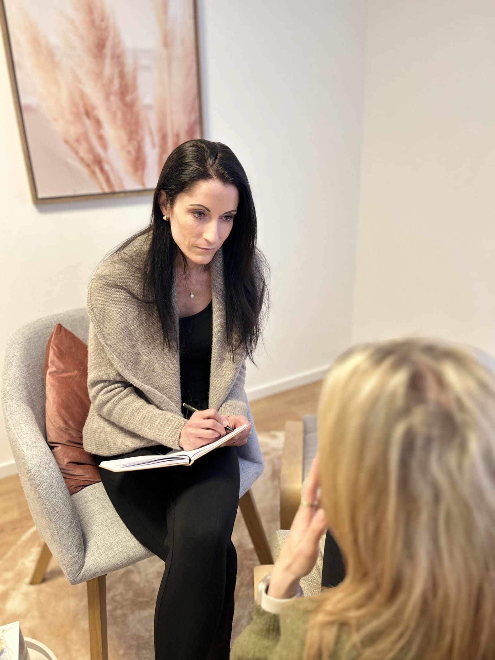 Hypnose Vorgespräch Bild von Heilpraktikerin Melis Achatz im Sessel sitzendbeim Anamnesegespräch mit einer Patientin vor der Hypnose bzw. Trance-Arbeit