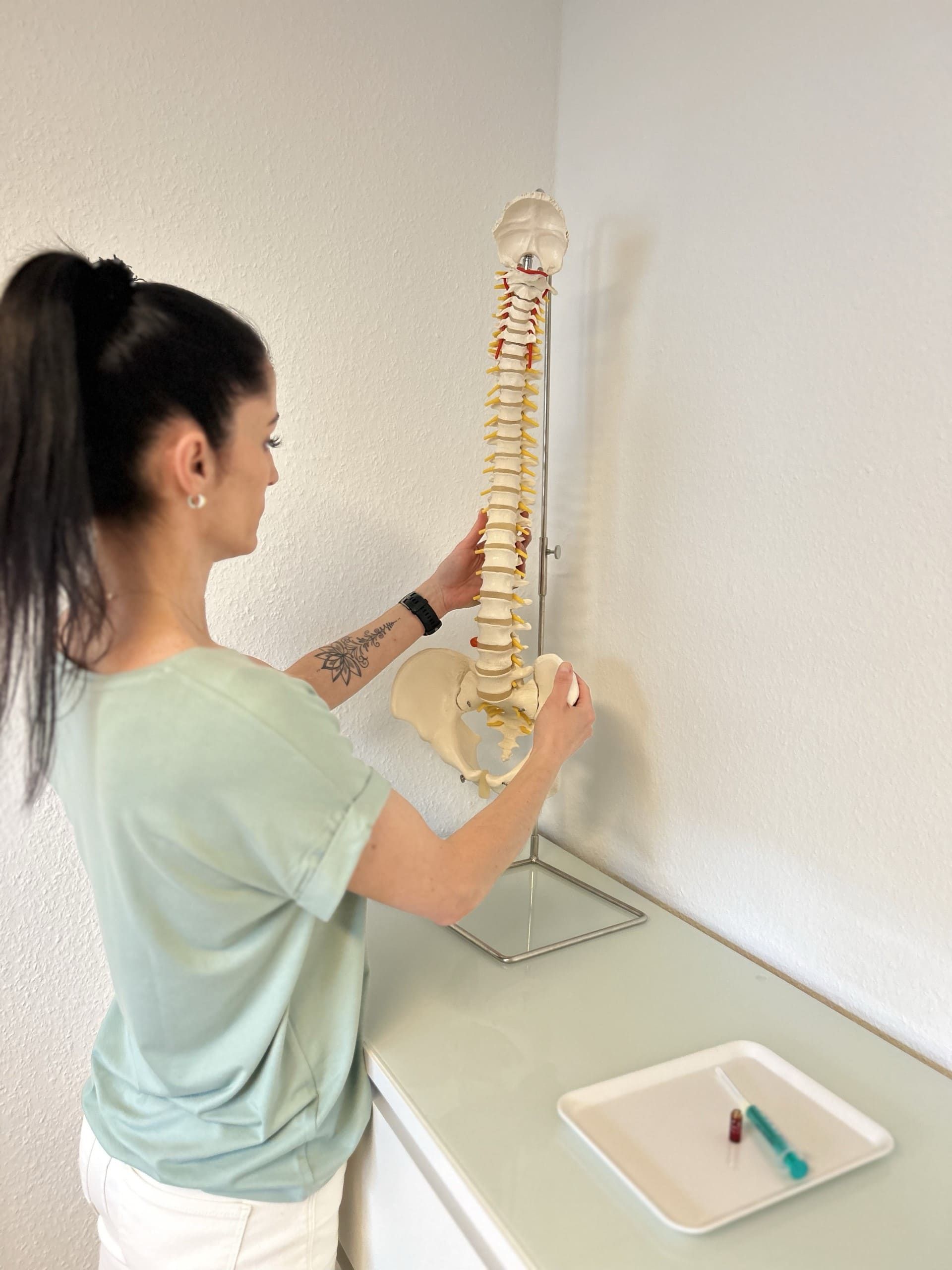 Heilpraktikerin Melis Achatz am Modell der Wirbelsäule