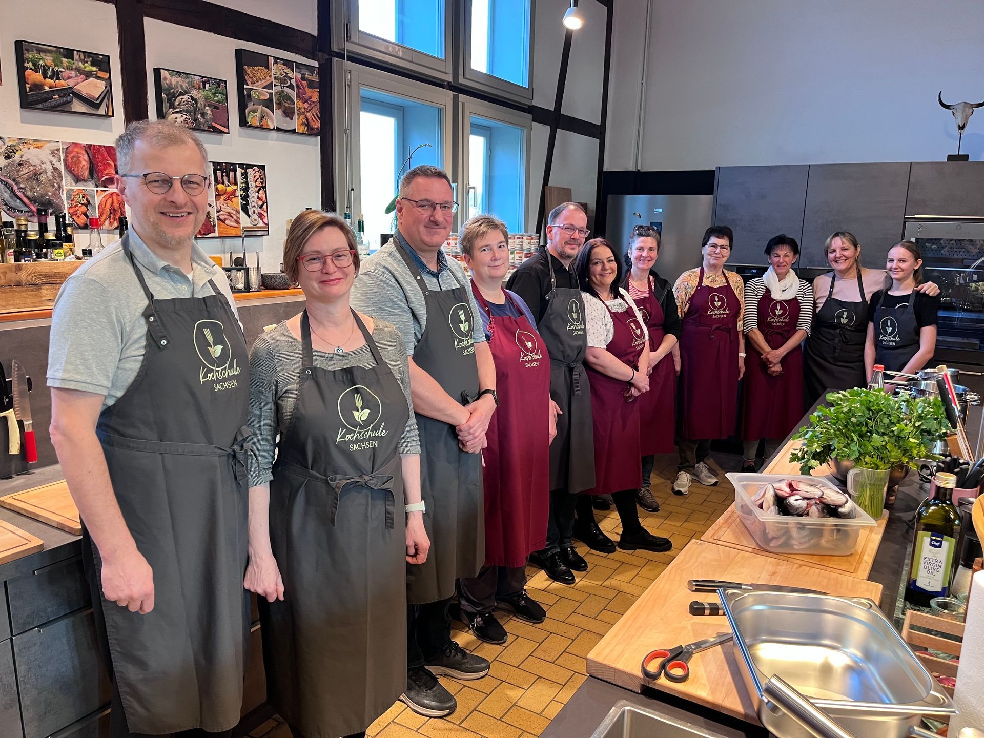 Gruppenfoto mit lächelnden Teilnehmenden in Kochschule