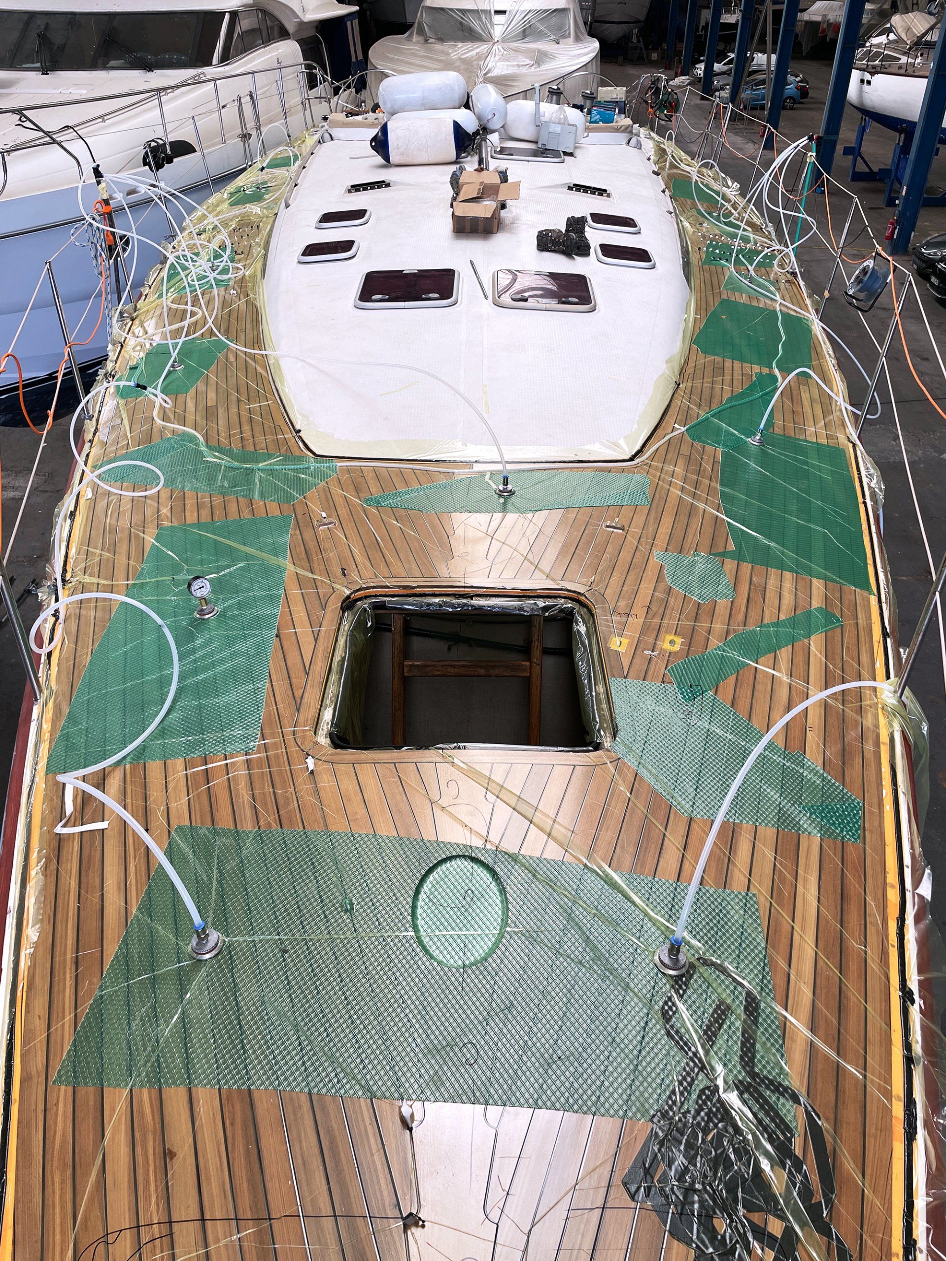 Vakuumverklebung des neuen Decks Ein neues Teakdeck wird vakuumverklebt auf eine Futuna 57