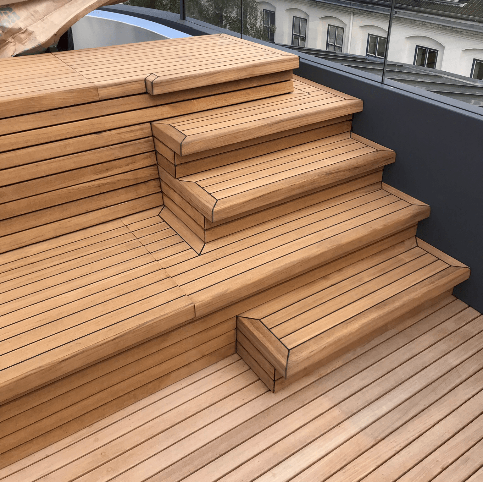 Teak Terassenbelag und Poolumrandung mit Treppenstufen aus Teakholz und einer Wegerung
