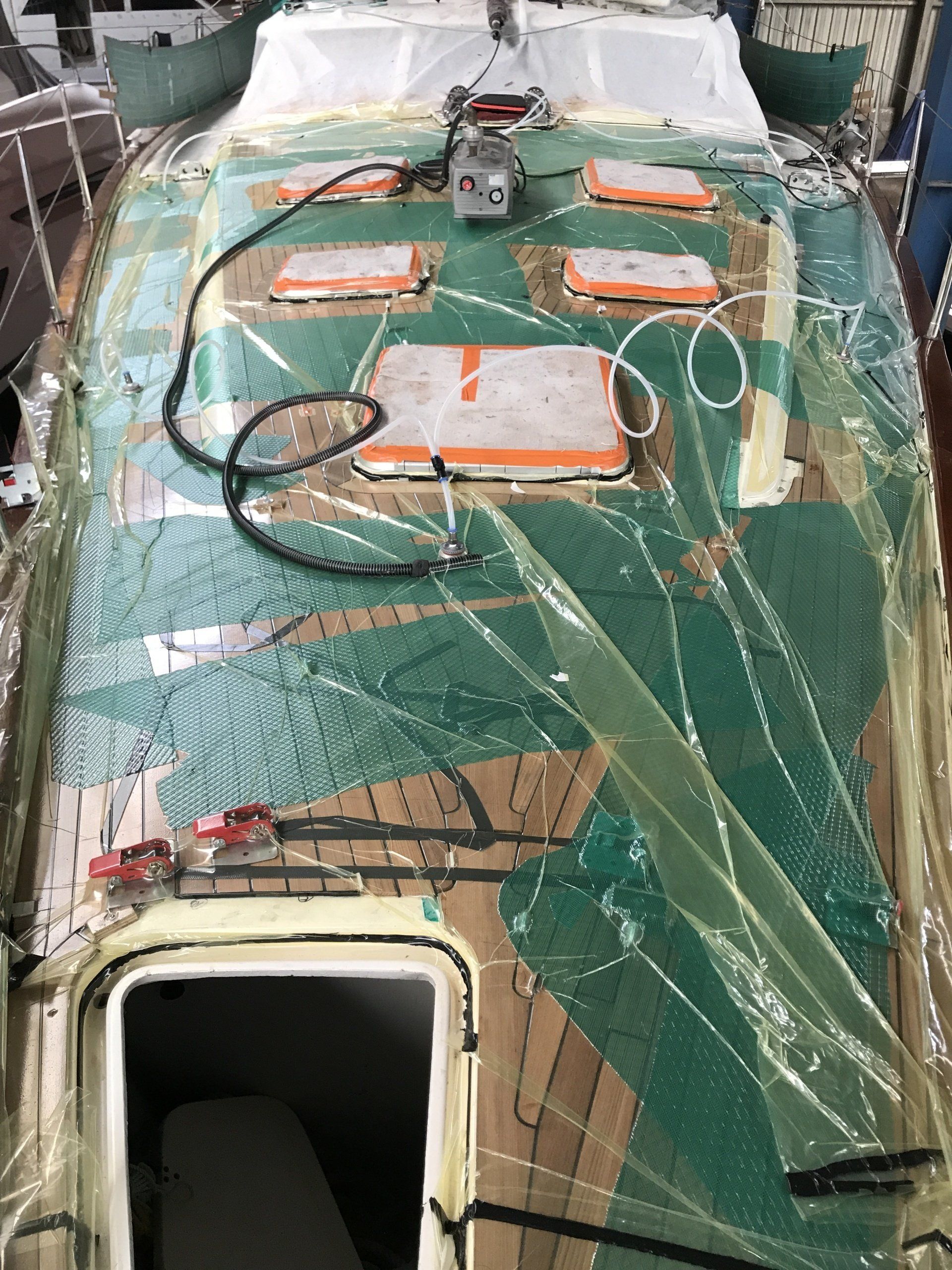 Vacuum bonding a teak deck to a Farr 60 sailing yacht