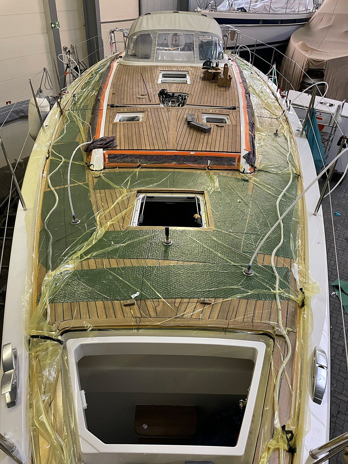 Vacuum bonding of a teak deck on an X-Yacht sailing yacht by Mobilerbootsbau teak decking company