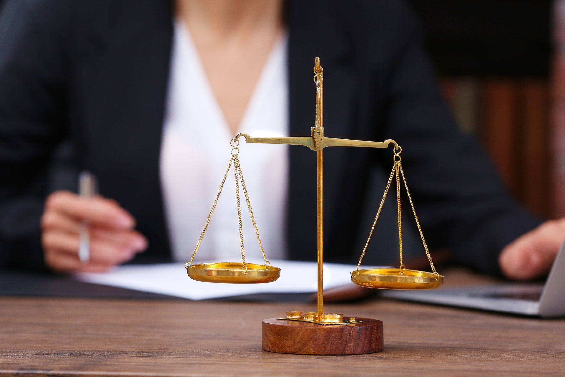 a woman at a desk with a legal balance scale in front of her