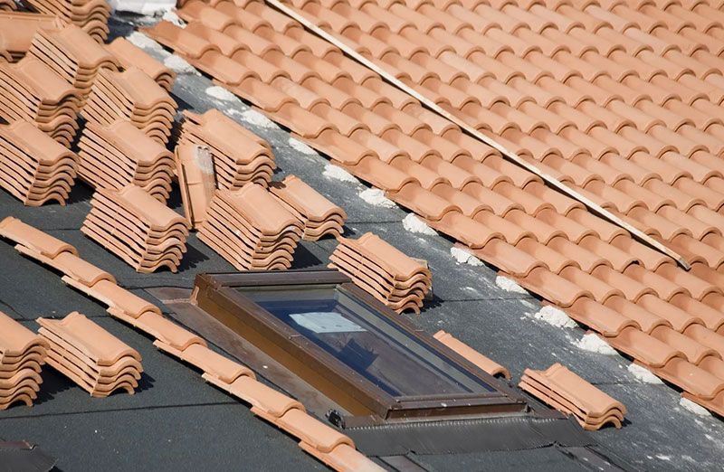 Ein Dachflächenfester auf einem gedeckten Dach mit roten Pfannen