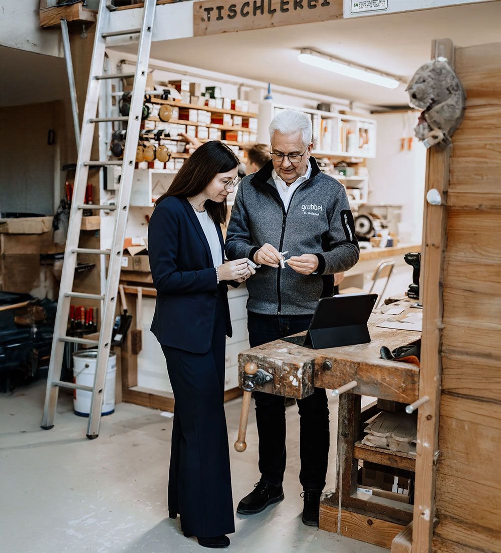 Ein Grübbel-Mitarbeiter berät eine Kundin im Geschäft