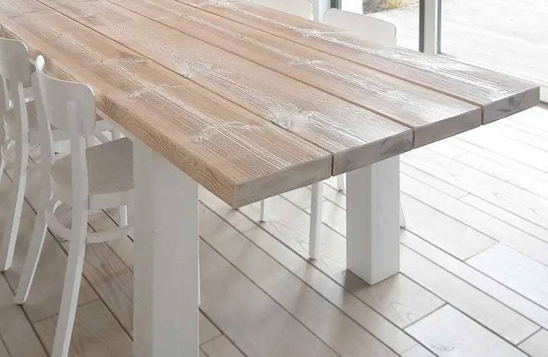 Ein gefertigter Wohnzimmertisch aus Holz mit weißen Stühlen