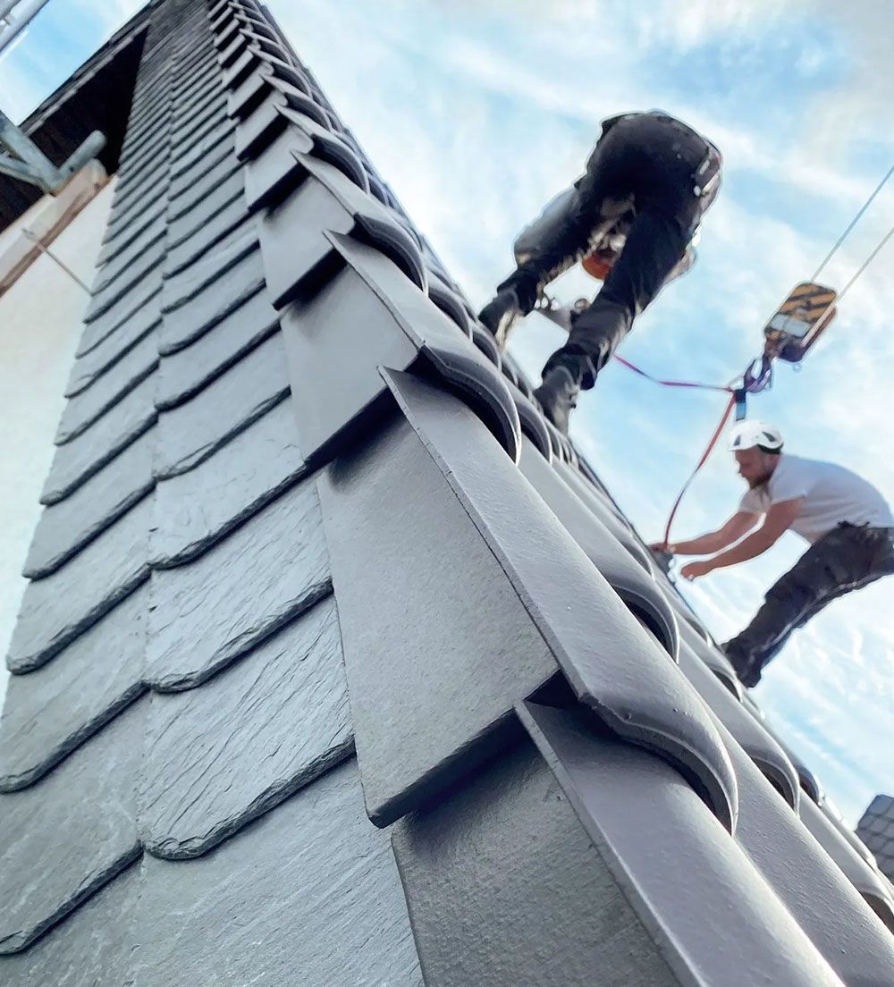 Zwei Dachdecker von Grübbel arbeiten an einem Dach