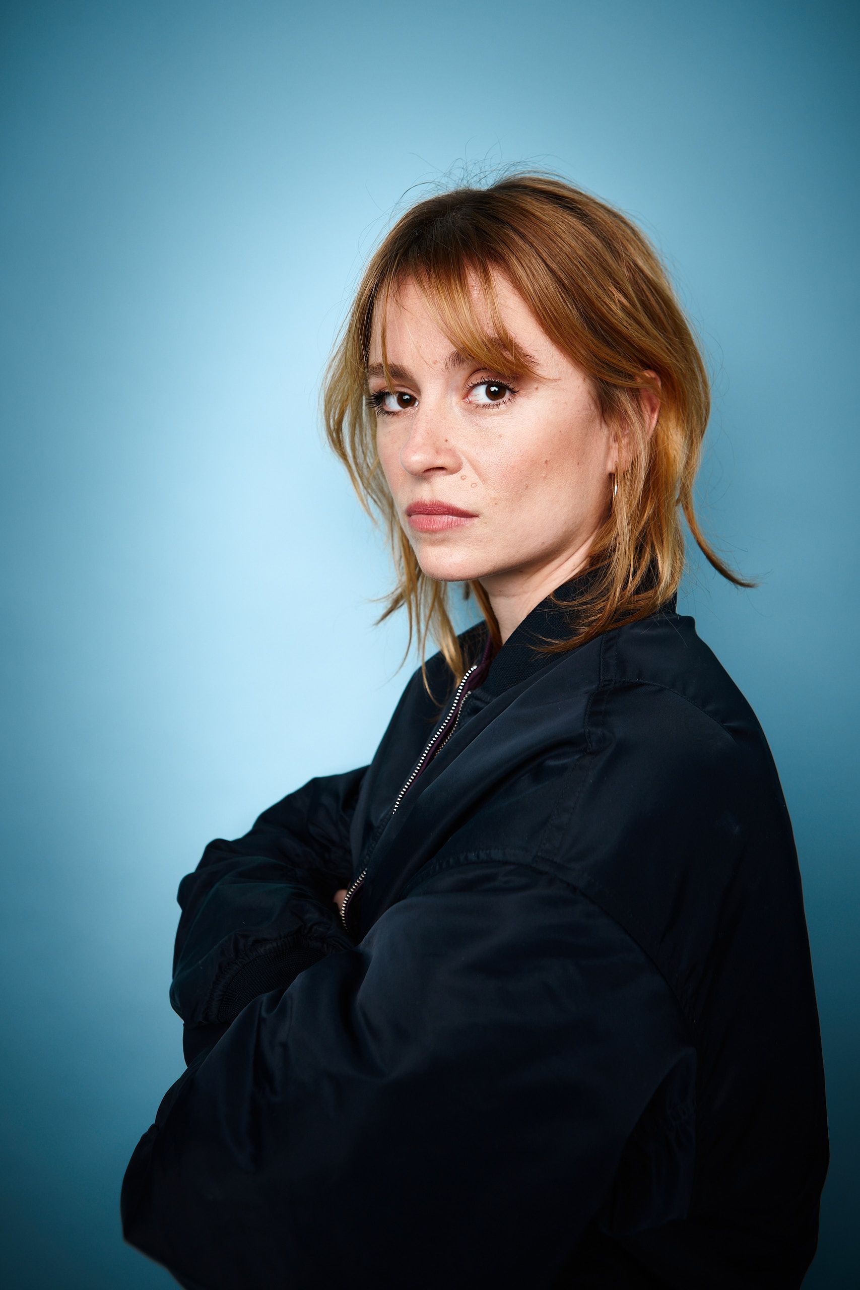 Headshot Schauspielerin Lilly Menke, blauer Hintergrund, Studioaufnahme