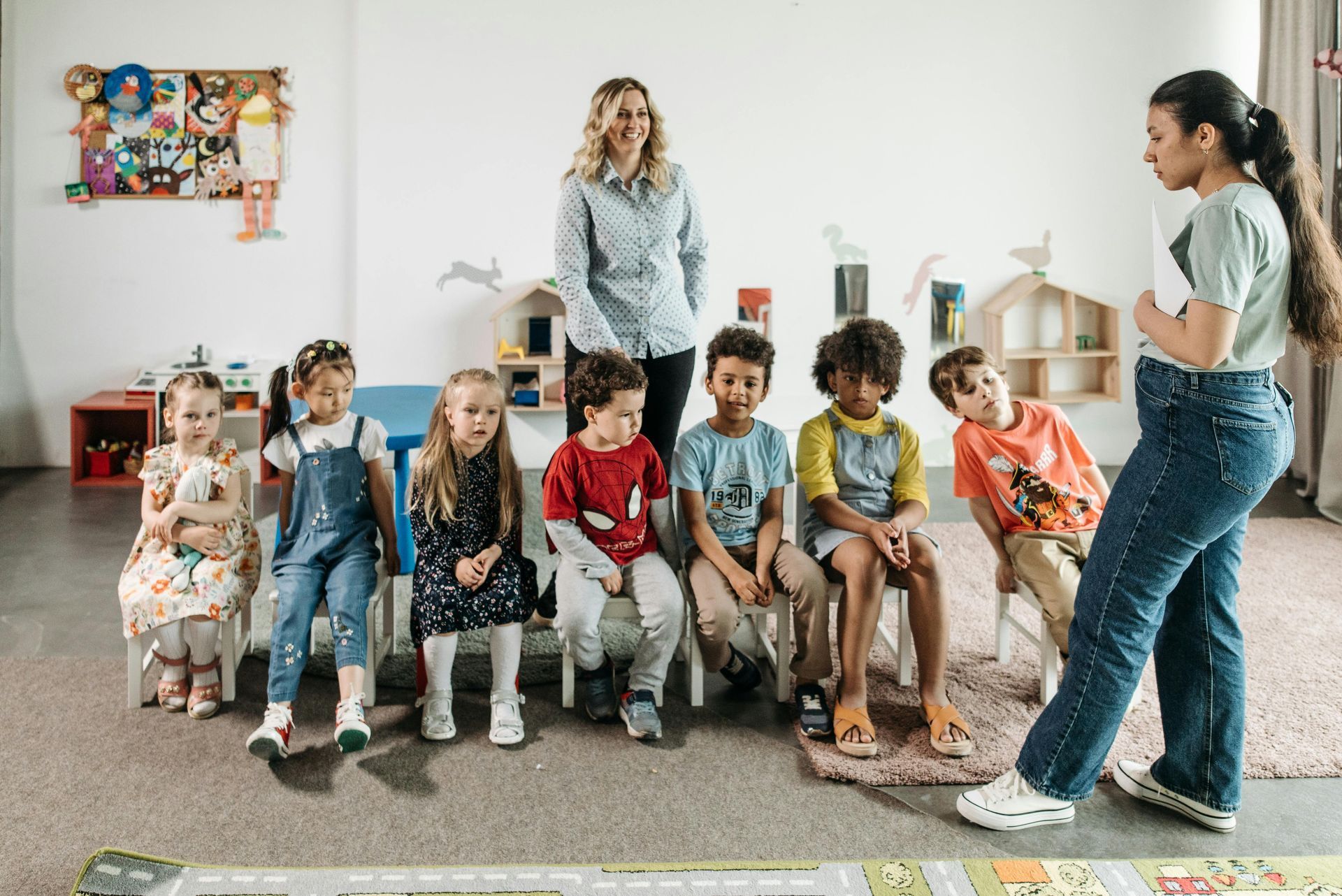 muchos niños sentados con dos profesoras