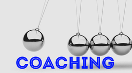 Coaching, Veränderung, Kugelspiel- Eine verchromte Kugel schwingt vor grauem Hintergrund um beim auftreffen stillstehende hängende Kugeln in Bewegung zu versetzen