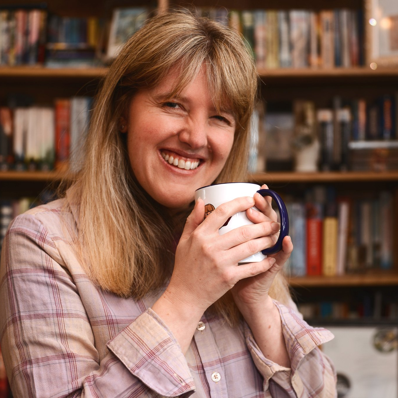 Female editor holding a mug and smiling