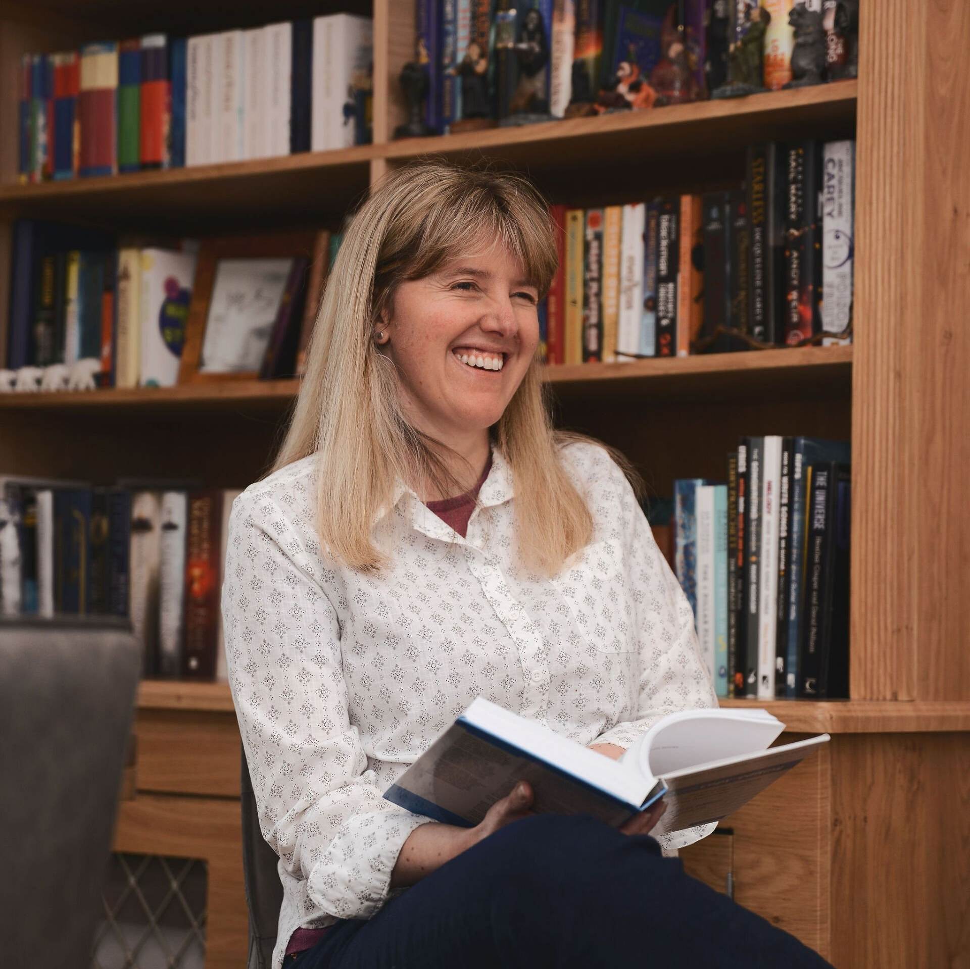 Female editor holding an open book and smiling