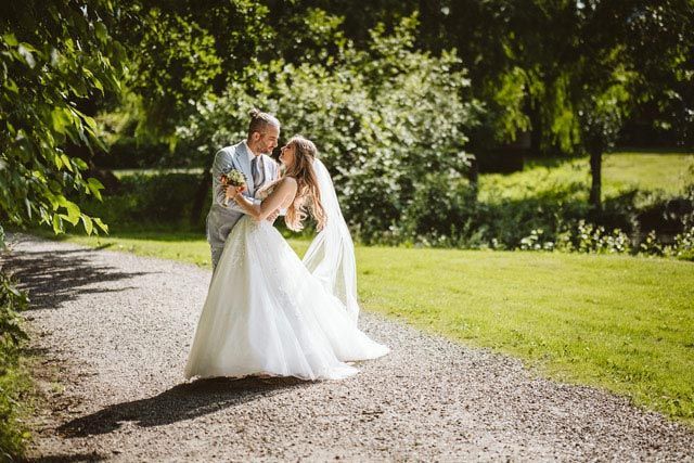 Paarfoto mit Fontaine im Hintergrund Bräutigam schaut auf die wundervolle Braut, im Hintergrund ist eine Fontaine