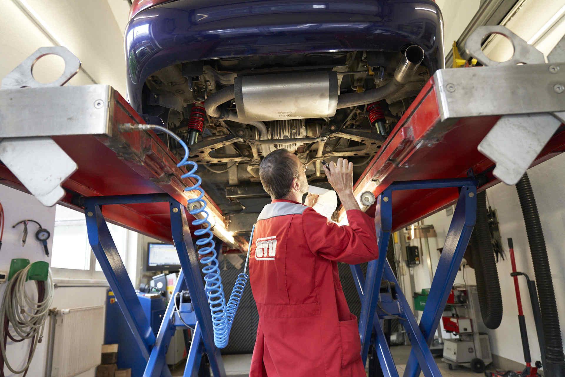 Titelbild zu Schadengutachten, Kfz-Meister macht Kfz-Sichtprüfung auf der Hebebühne