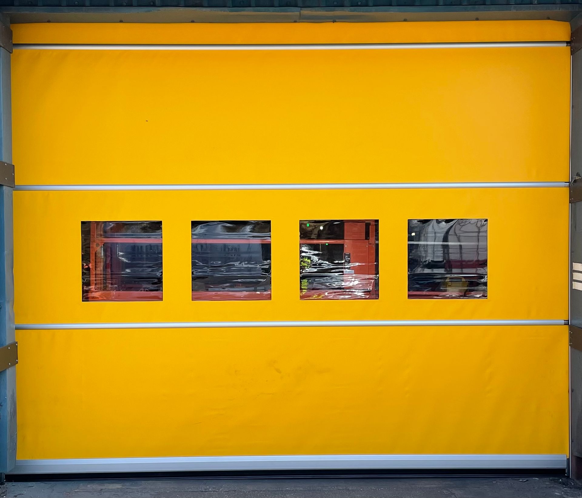 Yellow industrial roller door with four windows