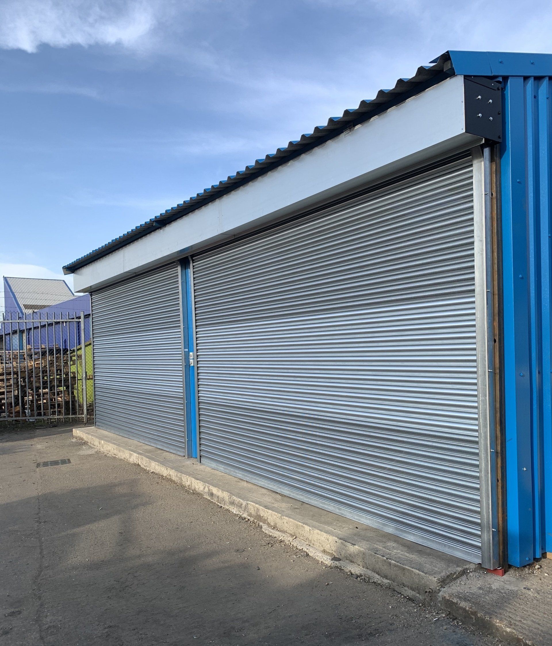 Silver roller shutter doors on blue warehouse
