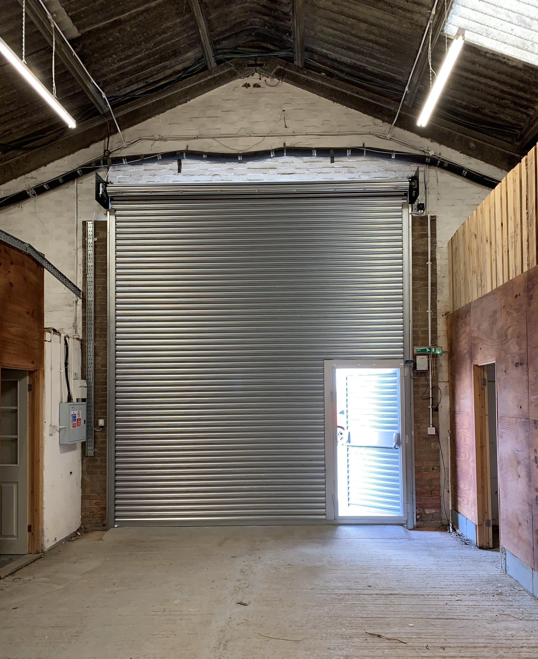 Warehouse roller shutter with side access door