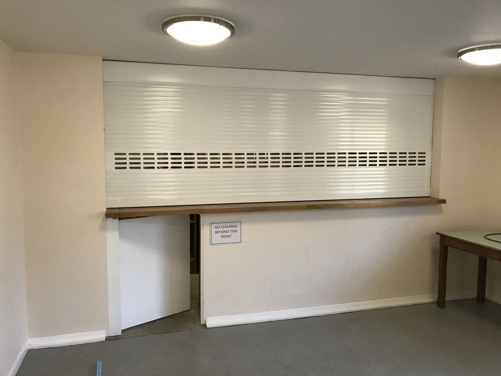 White roller shutter serving hatch in hall