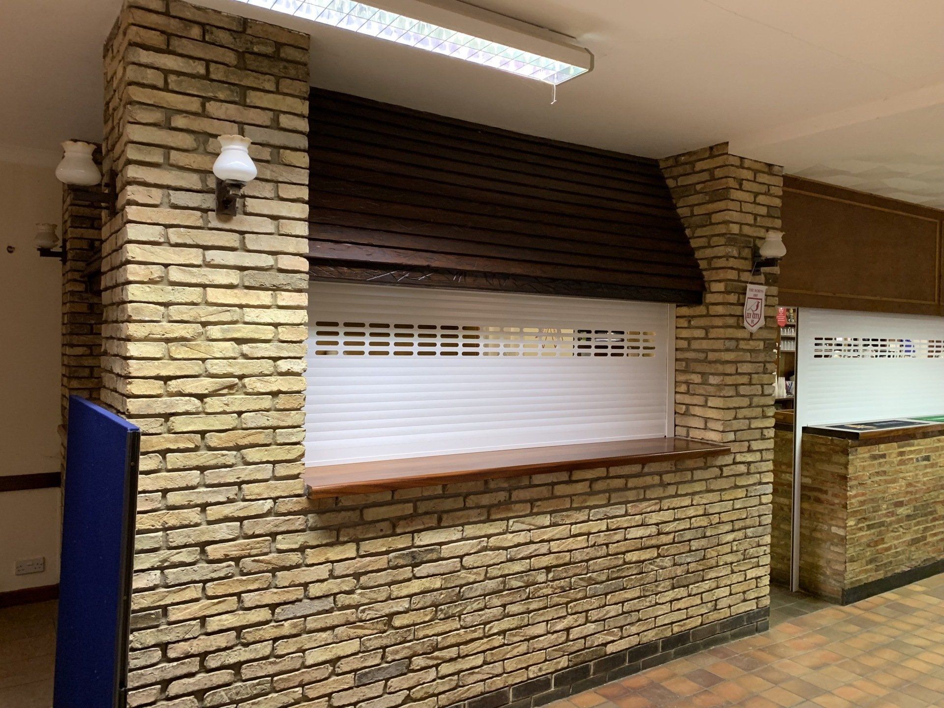 Black perforated roller shutter fitted on a commercial shopfront