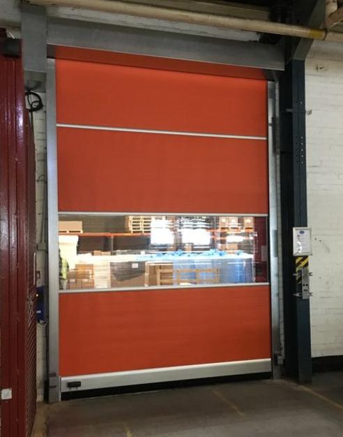 Orange high-speed industrial roller door with clear panel