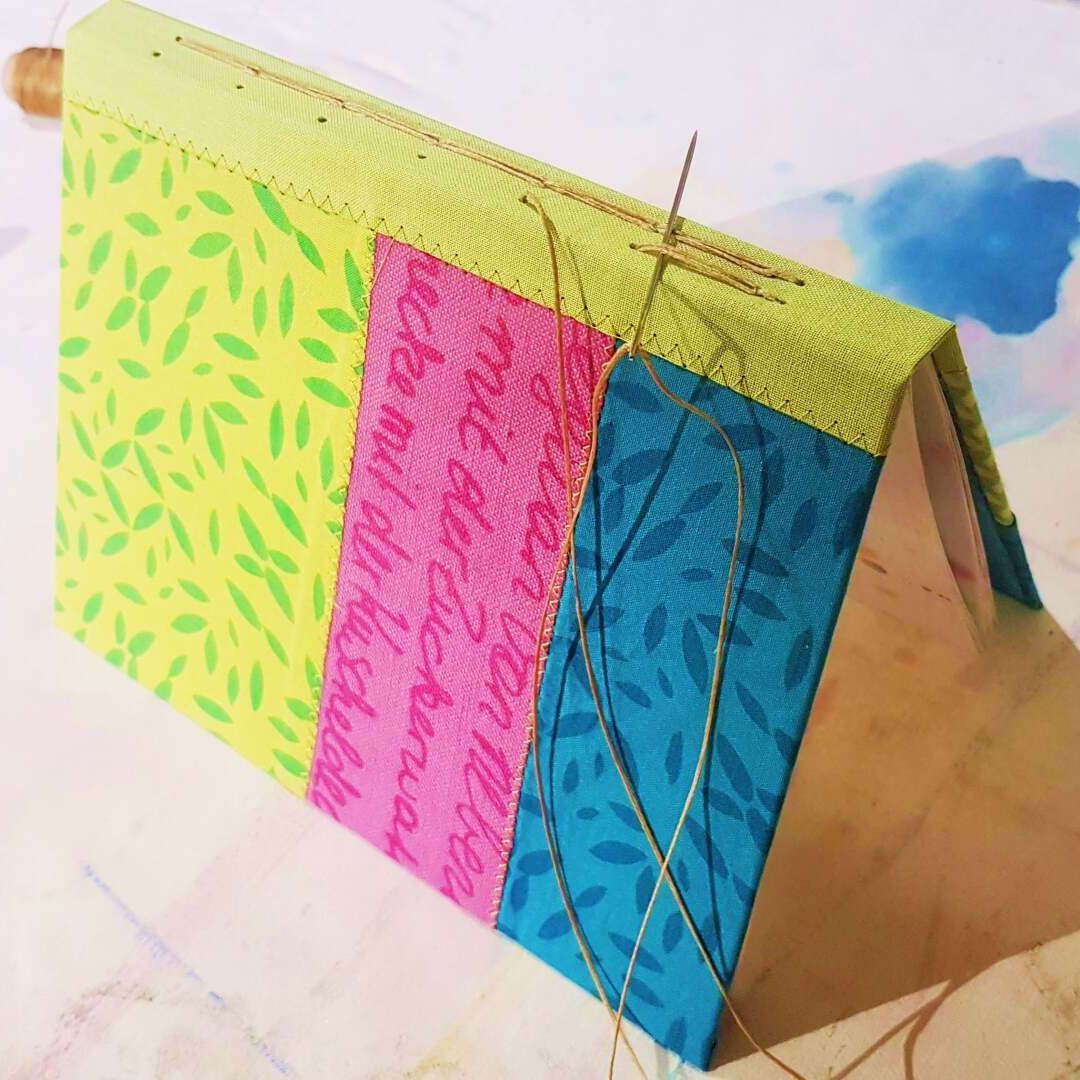 Buchbinden Buch mit Kettenstichbindung und textilem Einband, die Stoffe für den Einband wurden mit Siebdruck bedruckt