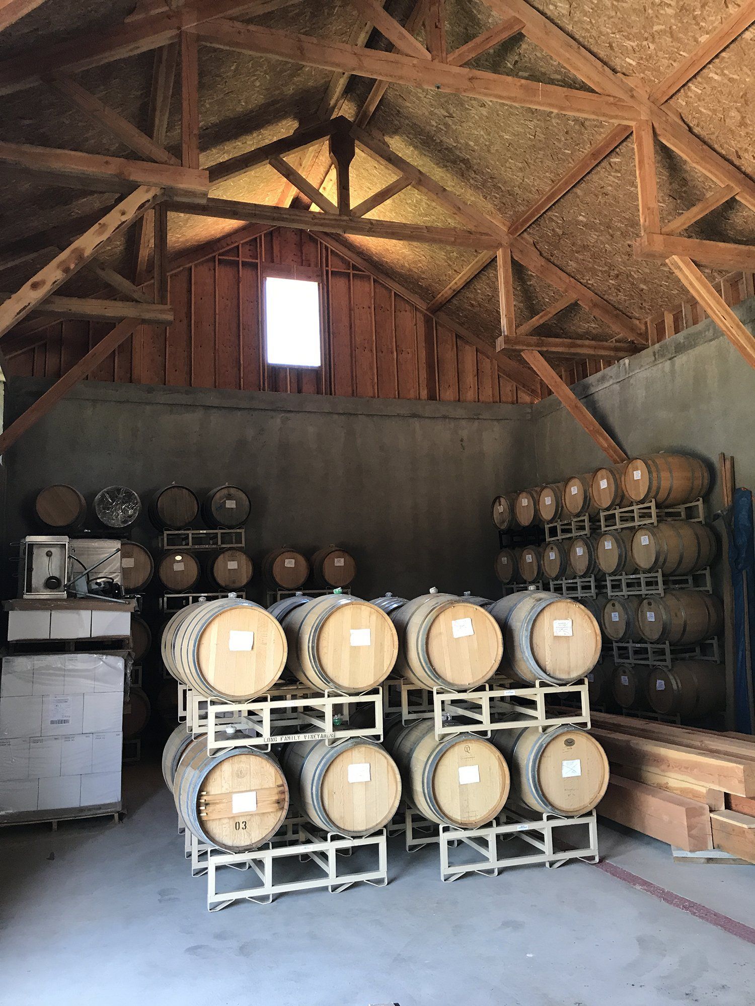 timber trusses in a barn with wine barrels