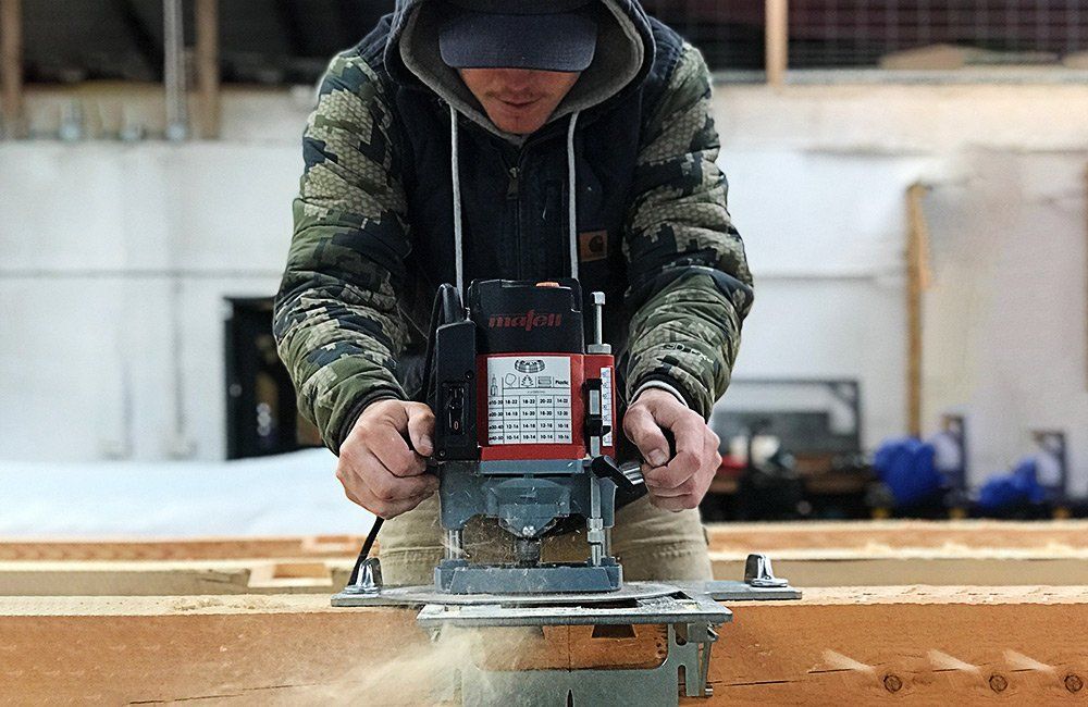 man sawing wooden post