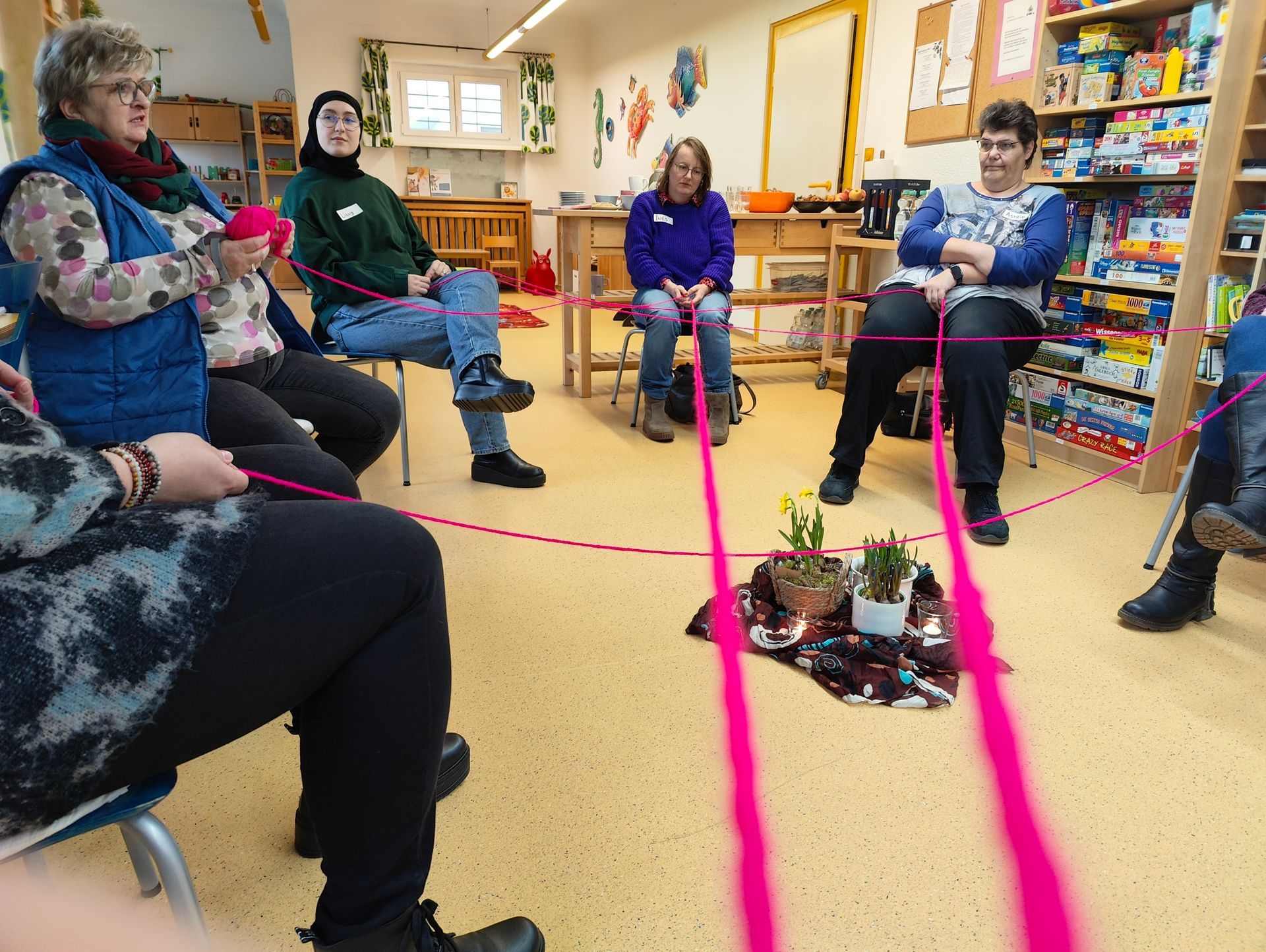 Abbildung Schulungsteilnehmer Familienpatenschulung mit Wollfäden in der Hand