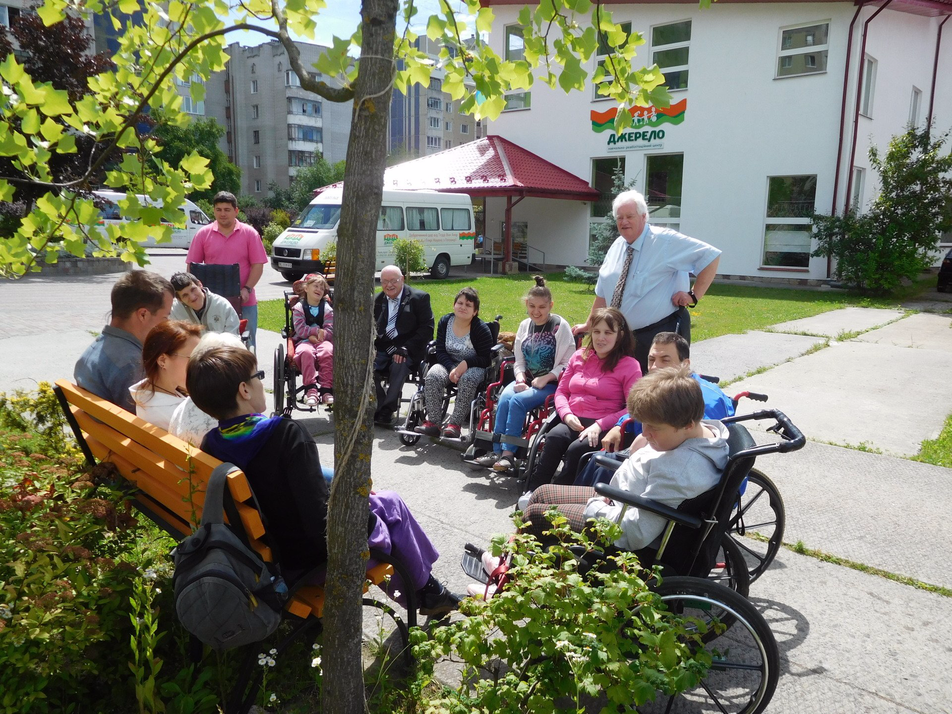 Michael Dunlop and Keith Robertson meeting and working with young disabled wheelchair users in Lviv outside in the Sun