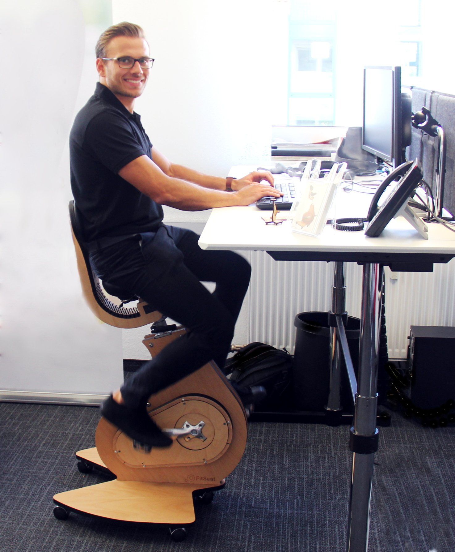 ein Bild, Mann sitzend auf Desktop-Bike am Schreibtisch