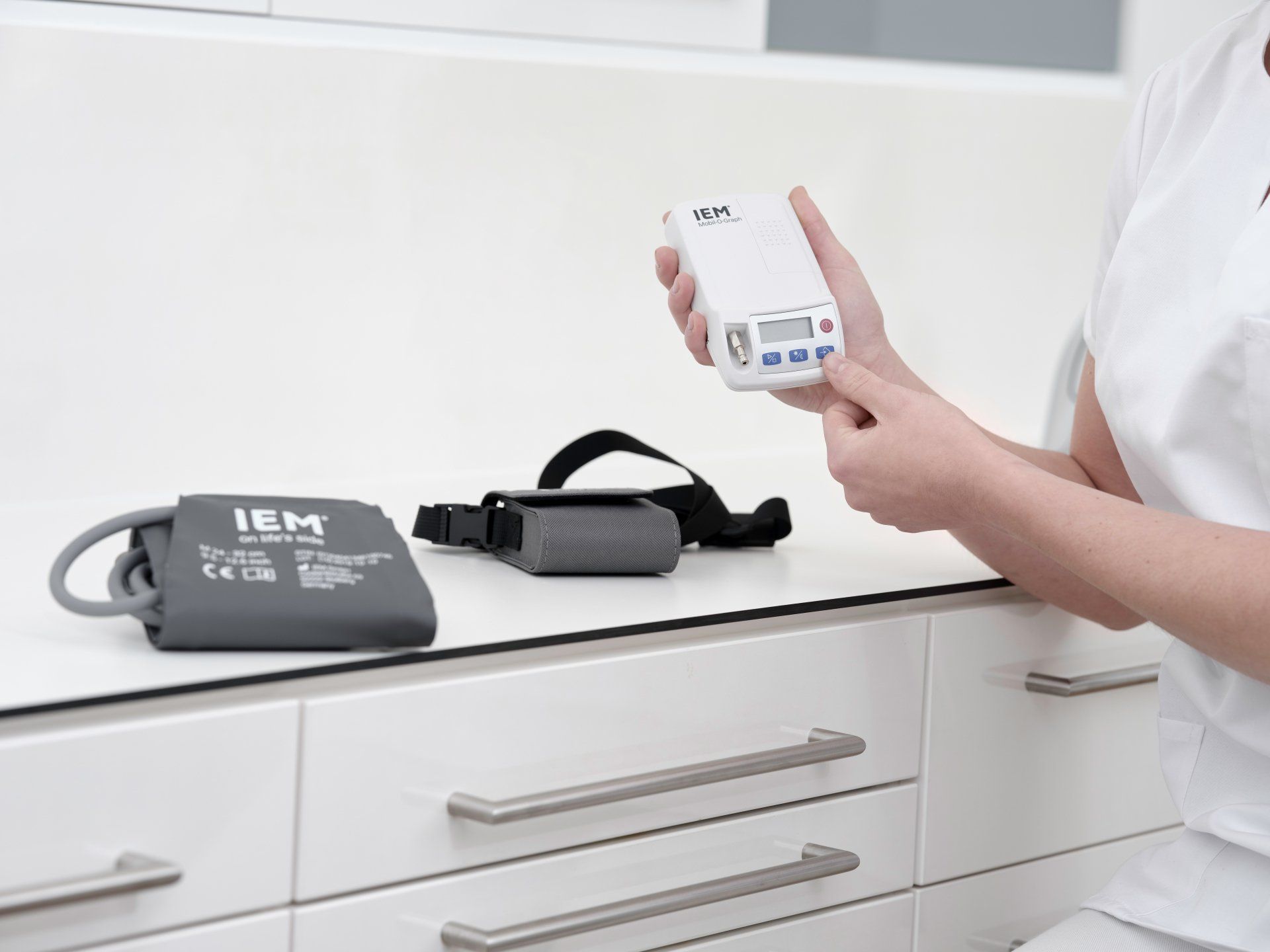 Ein Bild, Arztpraxis, Helferin stellt Blutdruckmessgerät ein