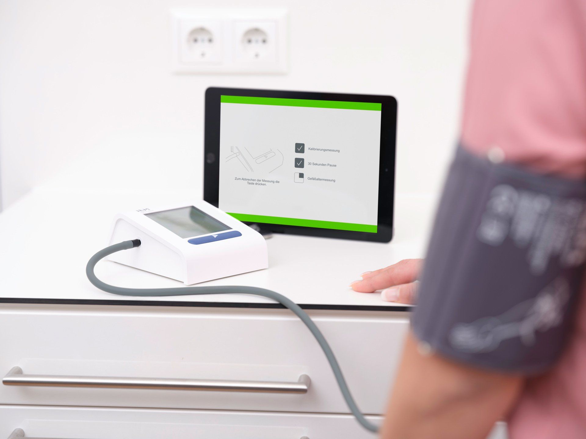 ein Bild, Blutdruckmesser mit Tablet, Oberarmmanschette am Arm