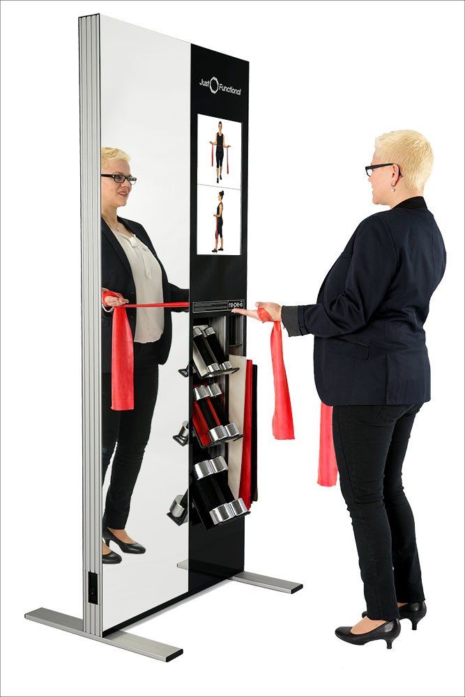 ein Bild, Just Functional, Frau vor der Übungsstation nimmt Theraband