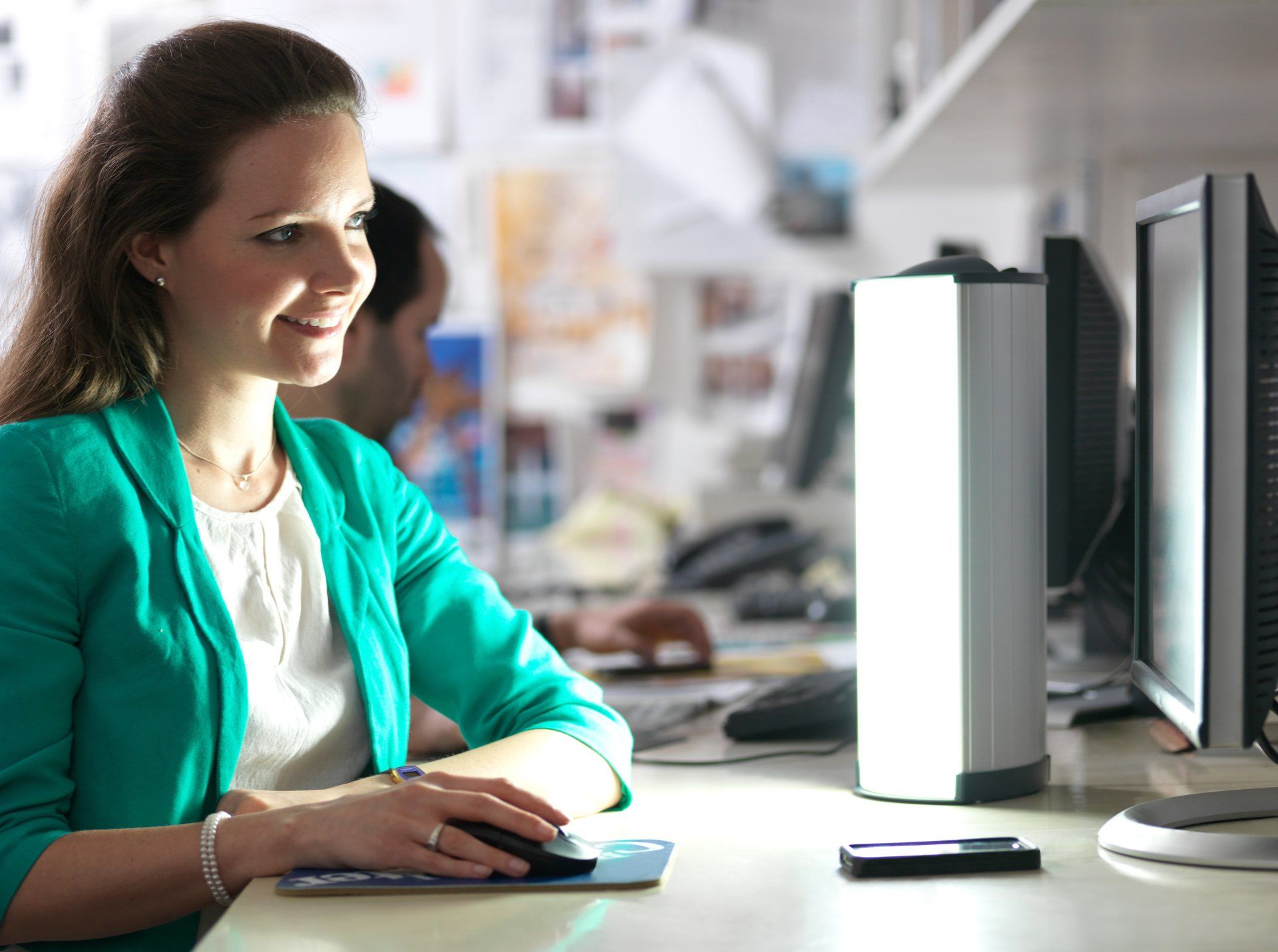 Ein Bild, junge Frau am Arbeitsplatz, Lichttherapiegerät
