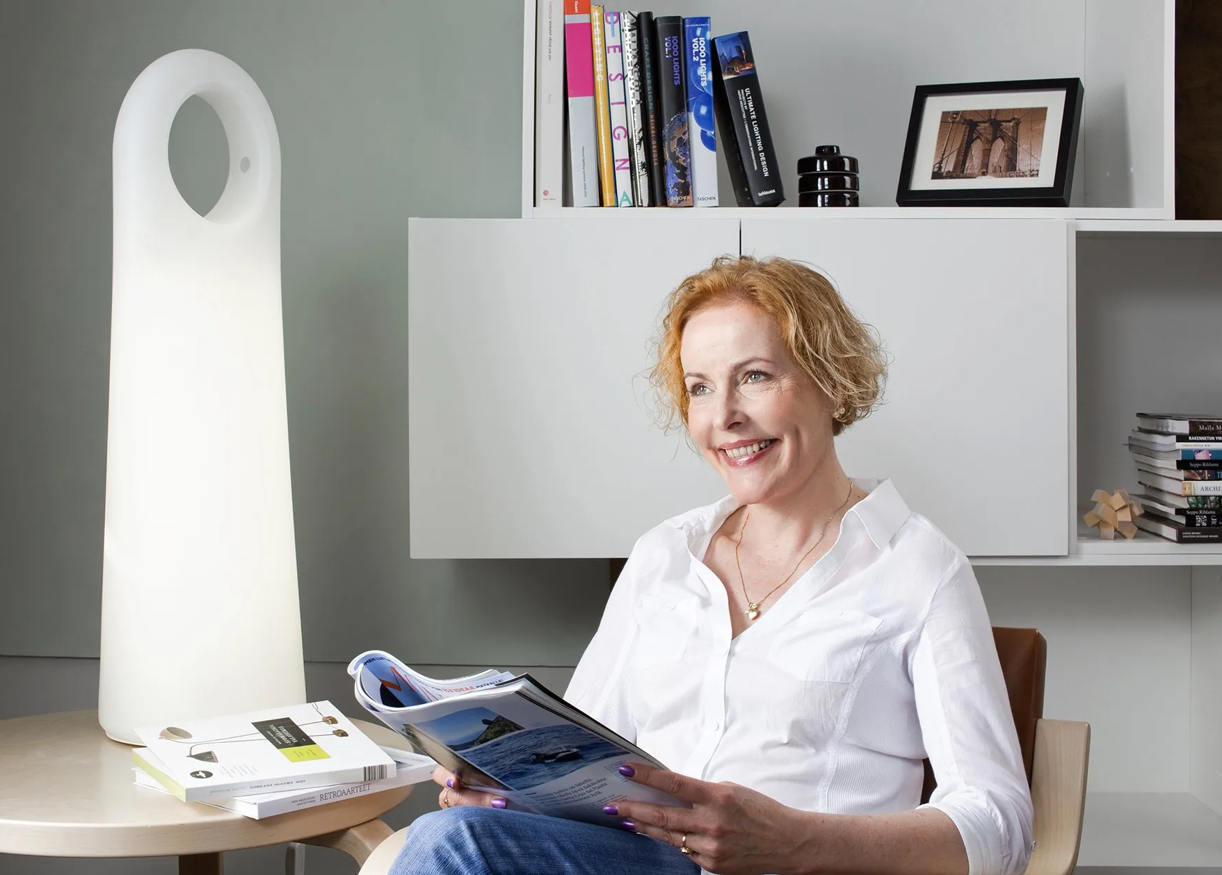 Ein Bild, Frau lesend im Wohnambiente, Lichttherapiegerät