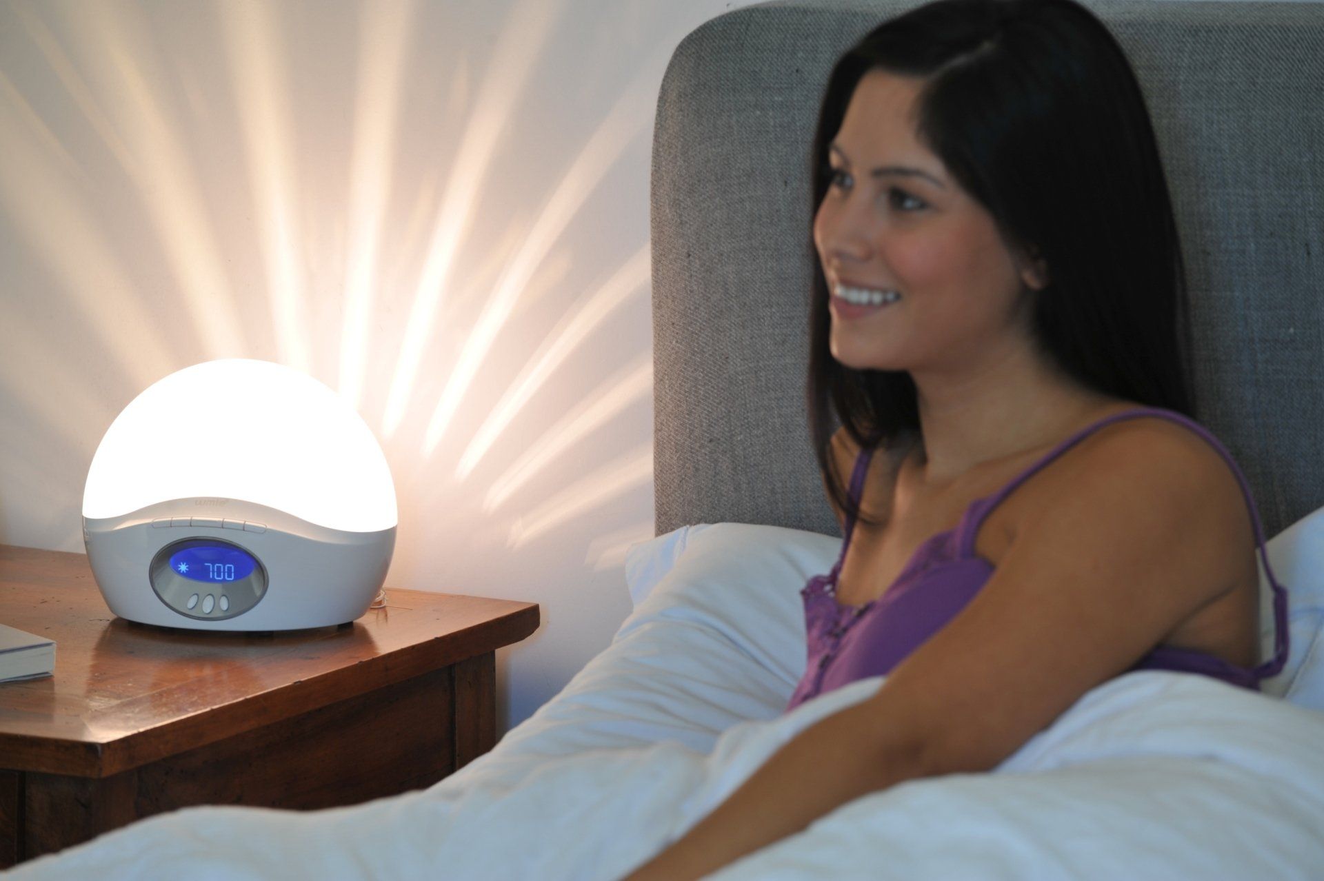 ein Bild, Frau sitzend im Bett, Lichtwecker hell erleuchtet