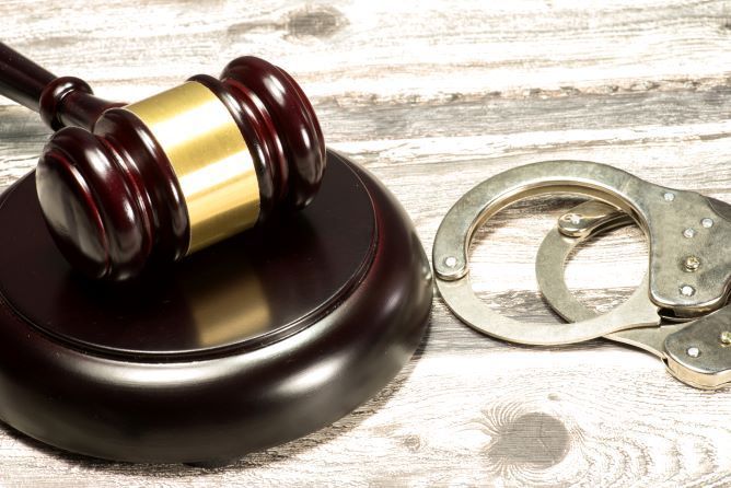 Bild zeigt Gerichtshammer und Handschellen