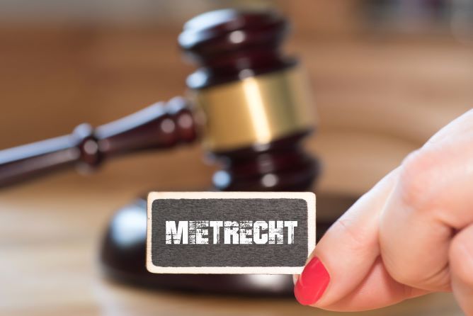 Bild zeigt Gerichtshammer und davor das von einer Hand gehaltene Wort Mietrecht