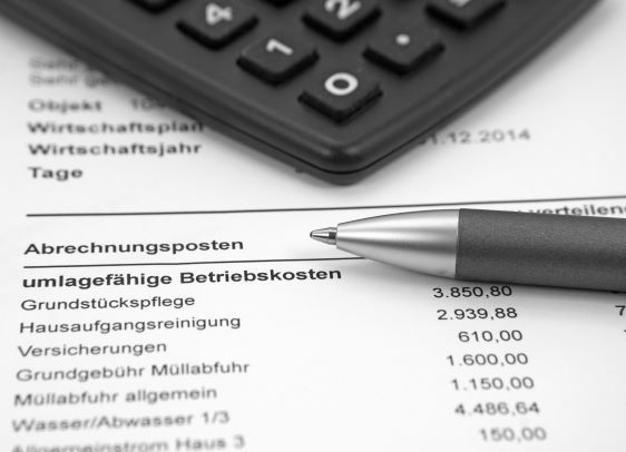 Bild zeigt Teil einer Betriebskostenabrechnung und einen Taschenrechner