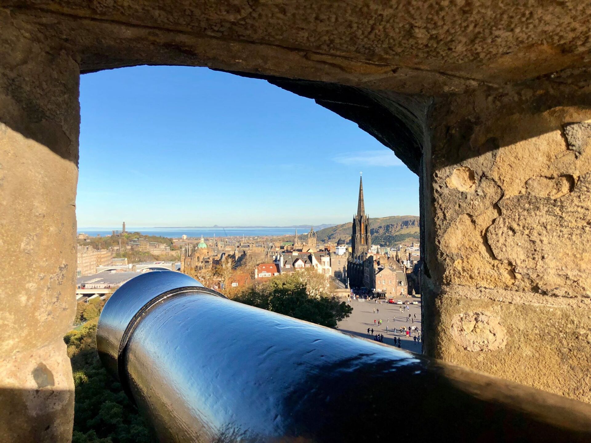A canon from inside Edinburgh Castle with a view over some of the iconic Edinburgh locations