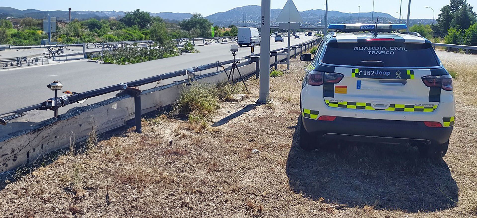 Coche de la Guardia Civil de Tráfico fuera de la carretera junto a un radar