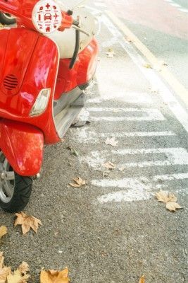 Moto scooter roja en una acera