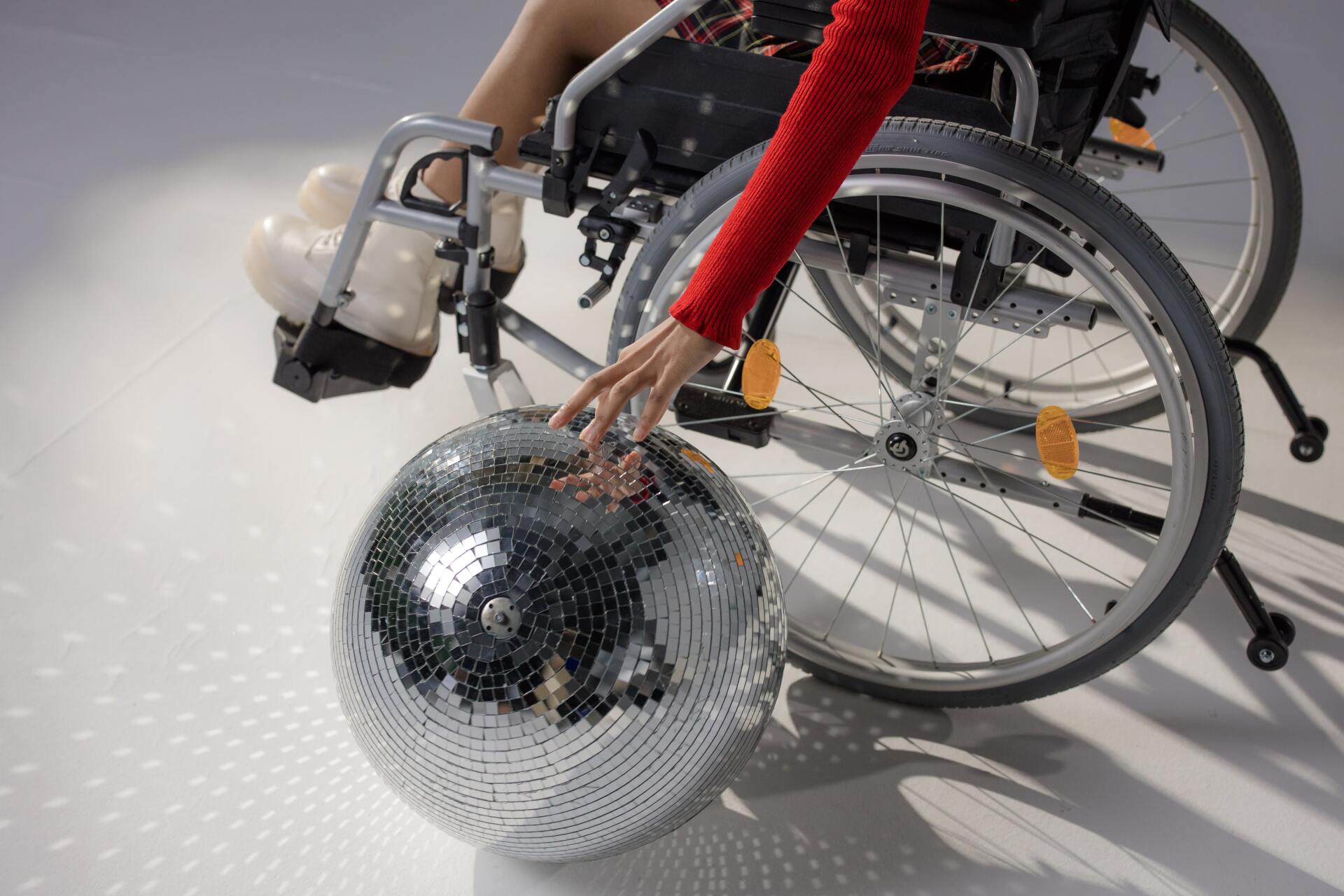 Persona en silla de ruedas con una bola de discoteca