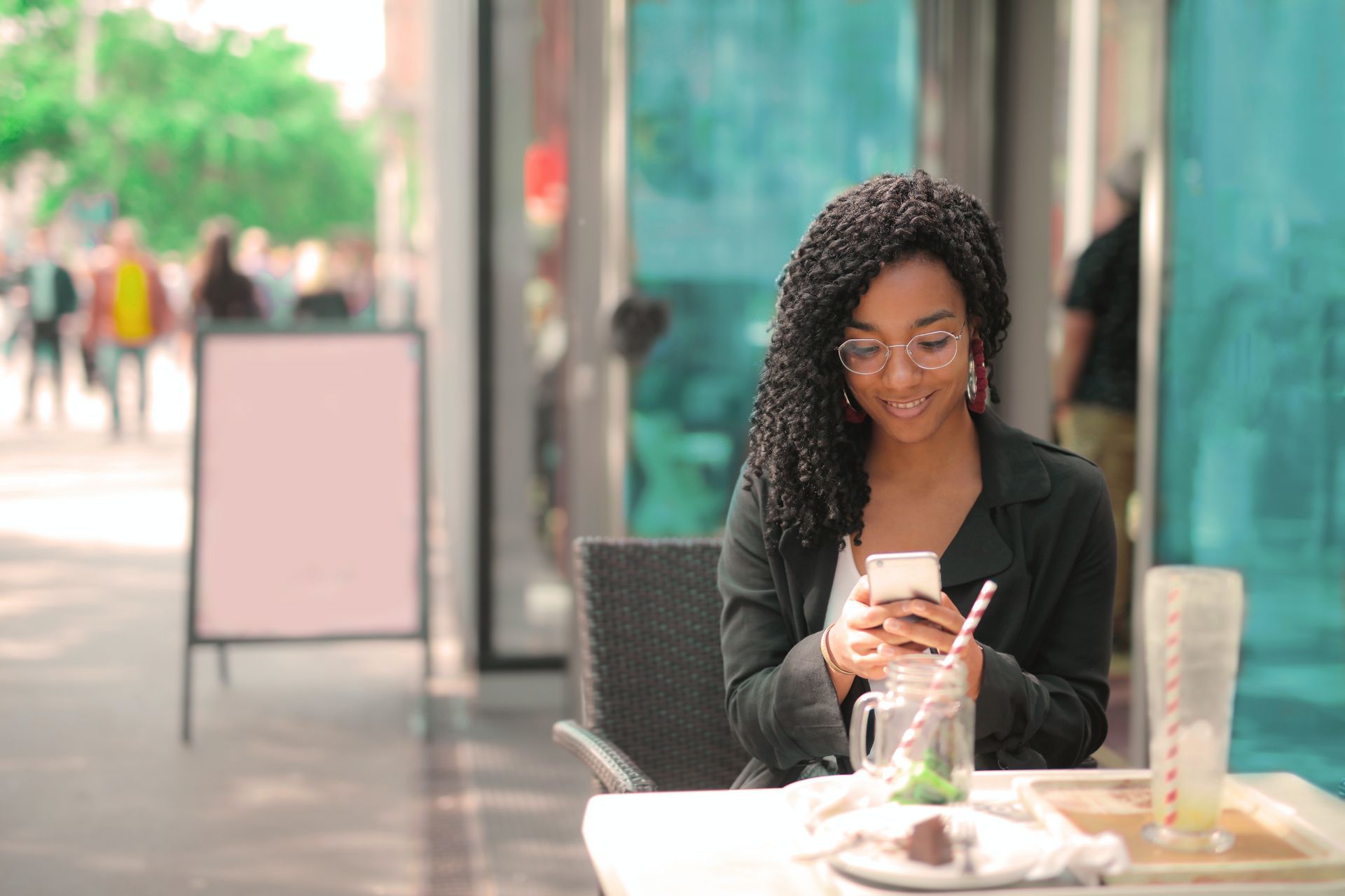 A young lady using her mobile phone at a cafe