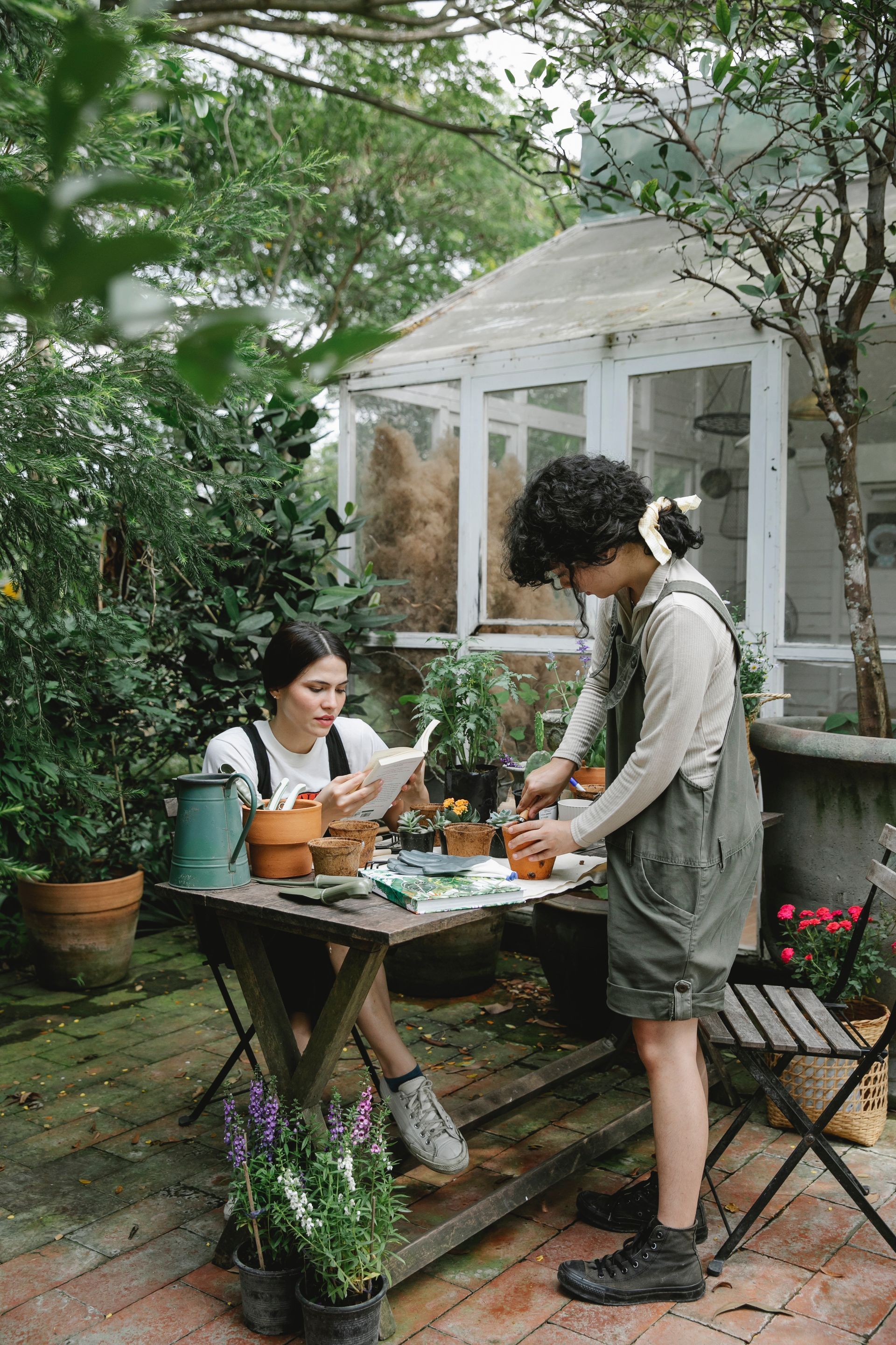 Two young ladies discussing their gardening project, in their garden