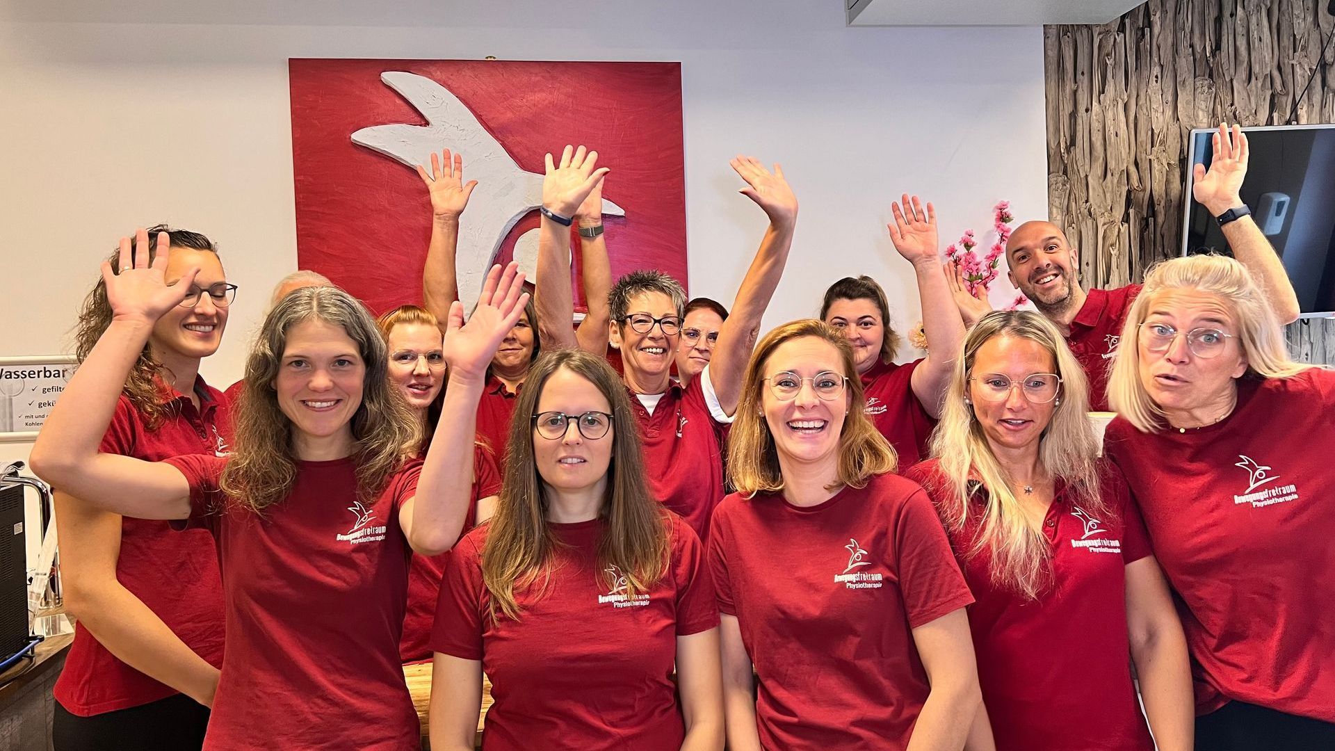 Unser Team hat gute Laune und winkt ins Foto.