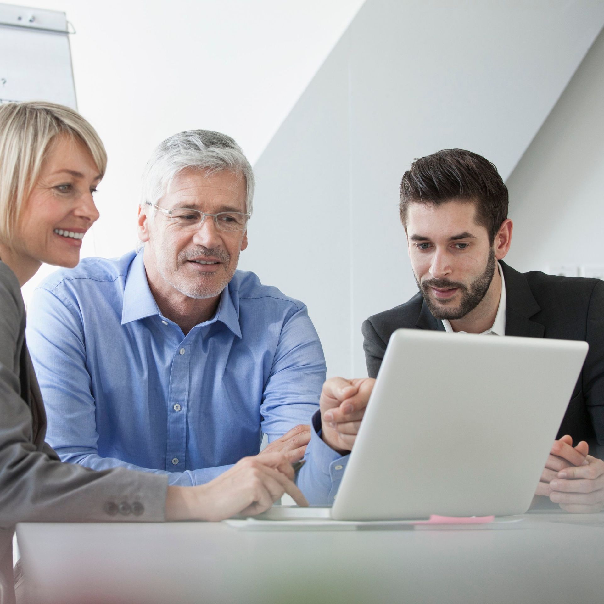 2 men and a woman talking at a computer