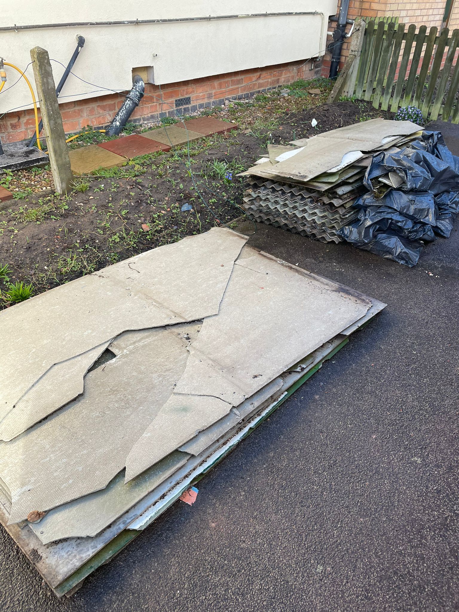 cement asbestos roofing sheets and side panels from a garage which are on a domestic driveway loose