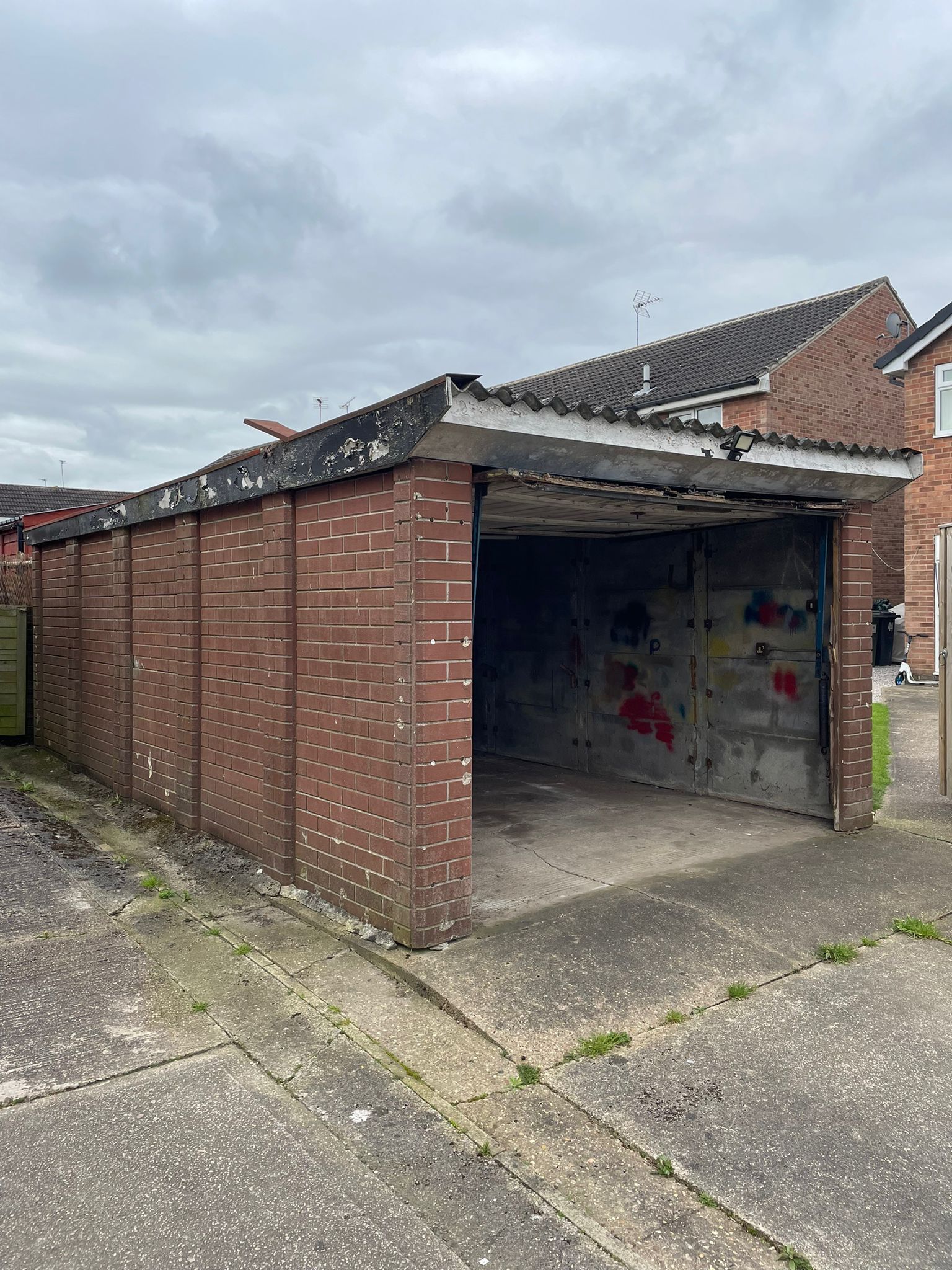 a brick garage with an asbestos roof at a domestic property